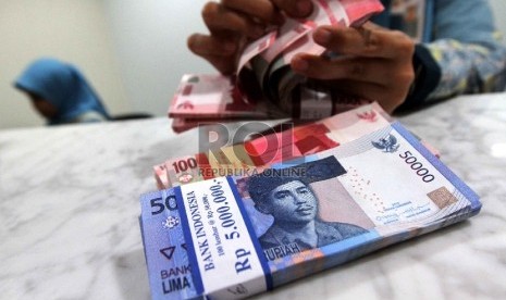 Teller menghitung rupiah di banking hall sebuah bank di Jakarta, Selasa (20/1).  (Republika/ Yasin Habibi)