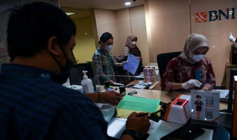 Teller menghitung uang di Bank BNI.Saham PT Bank Negara Indonesia Tbk. (BBNI) disebut memiliki prospek yang cerah didukung kinerja penyaluran kredit. Sinarmas Sekuritas memproyeksi pertumbuhan pinjaman BBNI akan meningkat tahun ini didorong oleh segmen korporasi.  