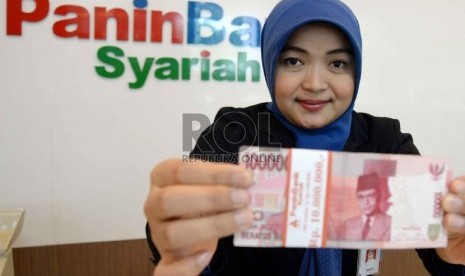  Teller menghitung uang rupiah di Banking Hall Bank, Jakarta, Senin (27/4).  (Republika/ Yasin Habibi)