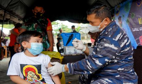 Tenaga kesehatan dari TNI AL berbincang dengan anak sekolah yaitu peserta vaksinasi massal di Lapangan Taruna Remaja, Kota Gorontalo, Gorontalo, Jumat (25/2/2022).