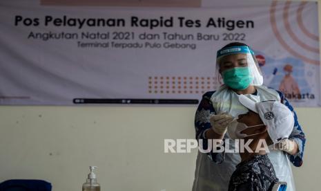 Tenaga kesehatan melakukan tes cepat antigen kepada seorang calon penumpang bus Antar Kota Antar Provinsi (AKAP) di Terminal Terpadu Pulo Gebang, Jakarta, Kamis (23/12/2021). Hasil negatif tes cepat antigen yang berlaku 1x24 jam menjadi salah satu syarat perjalanan darat untuk periode Natal 2021 dan Tahun Baru 2022 bagi pengguna transportasi bus AKAP serta mobil pribadi yang tertuang dalam SE Kemenhub Nomor 109 Tahun 2021. 