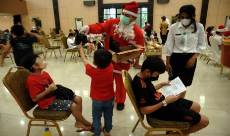 Tenaga kesehatan mengenakan kostum Sinterklas membagikan bingkisan kepada anak-anak saat mengantre vaksinasi COVID-19 di Manado, Sulawesi Utara, Rabu (15/12/2021). Operasi Sinterklas oleh Dinas Kesehatan Sulut merupakan bagian dari Program Vakisnasi COVID-19 untuk anak-anak usia 6-11 tahun yang dilaksanakan serentak di 11 provinsi yang telah memenuhi syarat capaian 70 persen vaksinasi umum dan 60 persen vaksinasi lansia.