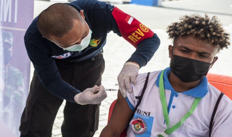 Tenaga kesehatan menyuntikan vaksin kepada warga ditengah pelaksaan PON Papua di halaman Stadion Akuatik, Kampung Harapan, Kabupaten Jayapura, Papua, Selasa (28/9/2021). Vaksinasi yang di gelar di empat klaster PON Papua merupakan langkah percepatan vaksinasi COVID-19 bagi warga atau pengunjung selama perhelatan PON di Papua. 