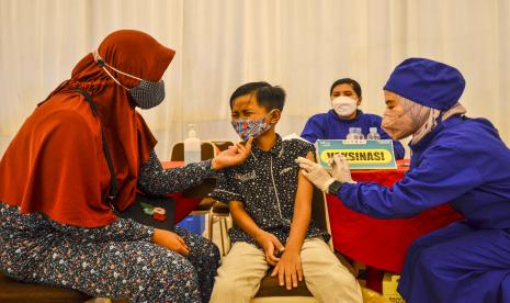 Tenaga kesehatan menyuntikan vaksin Sinovac kepada seorang anak di Graha Asia Plaza, Kota Tasikmalaya, Jawa Barat.