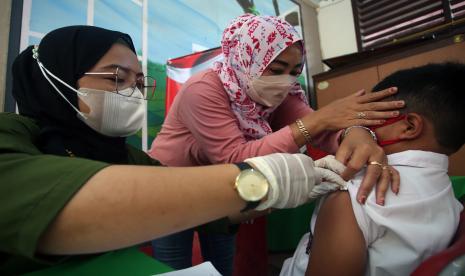 Tenaga kesehatan menyuntikkan vaksin COVID-19 dosis kedua kepada seorang anak di SDN 01 Pinang, Tangerang, Banten, Jumat (28/1/2022). Badan Intelijen Negara Daerah Banten bekerja sama dengan Pemkot Tangerang melakukan percepatan vaksinasi COVID-19 untuk anak di tengah naiknya kembali lonjakan penyebaran varian Omicron. 