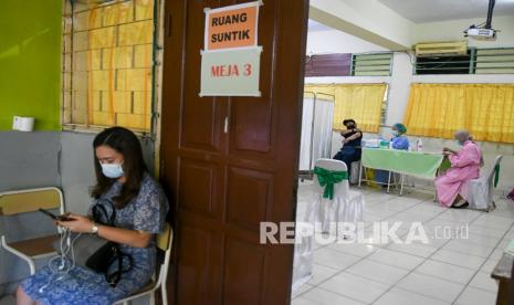 Tenaga kesehatan menyuntikkan vaksin COVID-19 pada tenaga pendidik di SMP 216, Jakarta, Selasa (6/4/2021). Dinas Pendidikan DKI Jakarta menargetkan guru dan tenaga pendidik sebanyak 142.403 orang akan divaksinasi sebagai upaya mencegah penyebaran COVID-19 di lingkungan sekolah dan persiapan jelang rencana Kegiatan Belajar Mengajar (KBM) tatap muka yang akan uji coba pada 7 April mendatang.