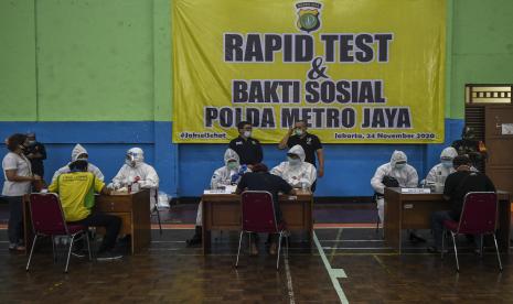 Tenaga medis melakukan tes cepat (rapid test) Covid-19 terhadap warga di Gelanggang Olahraga Tebet, Jakarta, Senin (23/11). Polda Metro Jaya menyelenggarakan bakti sosial penyemprotan cairan disinfektan dan tes cepat atau rapid test Covid-19 karena adanya temuan kasus terkonfirmasi positif dari acara Maulid Nabi Muhammad SAW di Tebet. Kegiatan serupa juga dilakukan di Petamburan, Jakarta Pusat, 