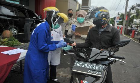 Tenaga medis mengambil sampel darah pengendara sepeda motor saat tes diagnosa cepat (rapid test) drive-thru di Rumah Sakit Bhayangkara Palembang, Sumsel. Gugus Tugas Percepatan Penanganan COVID-19 Sumatra Selatan mengingatkan protokol kesehatan di lokasi-lokasi wisata harus ketat dan tegas mengingat provinsi tersebut sebagian besar masih menangani kasus aktif.