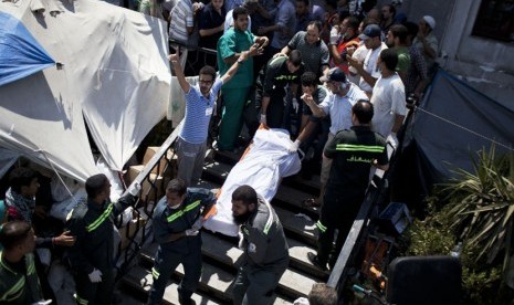  Tenaga medis mengevakuasi jasad pendukung Mursi yang tewas ditembak militer dalam bentrokan di Nasr City, Kairo, Sabtu (27/7). (AP/Manu Brabo)