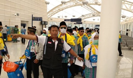 Tenaga pendukung PPIH Arab Saudi mengarahkan jamaah di Bandara Amir Muhammad bin Abdulaziz, Madinah, Sabtu (21/7).