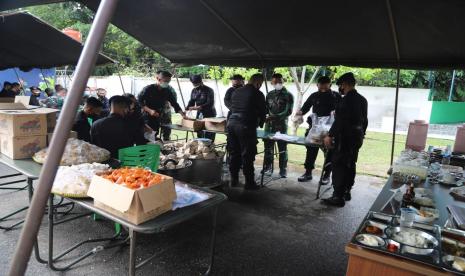 Tenda penyiapan makanan bernutrisi di dapur umum yang dikelola Korem 031 Wira Bima dengan melibatkan Polda Riau dan pemerintah daerah setempat. Personel TNI dan Polri sedang membungkus makanan yang kemudian akan didistribusikan pada Ahad (8/8) ke koramil-koramil setempat di wilayah Pekanbaru dan sekitarnya.