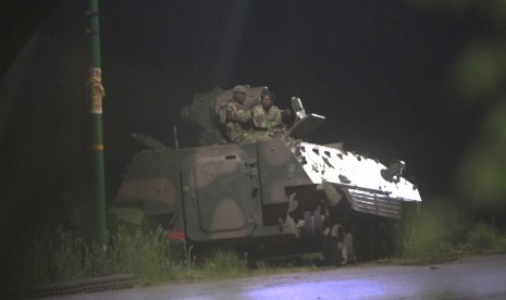 Tentara bersenjata Zimbabwe duduk di atas tank di Harare, Zimbabwe, Rabu dini hari (15/11).