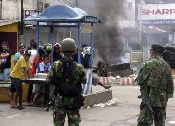 Tentara dan warga berjaga-jaga di Kota Ambon, Senin, setelah kerusuhan melanda daerah tersebut.