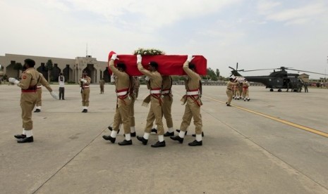 Tentara membawa peti jenazah yang dibungkus bendera merah putih Indonesia di Bandar Udara Nur Khan di Islamabad (9/5). Istri Dubes RI untuk Pakistan tewas setelah mengalami kecelakaan helikopter, Jumat (8/5).