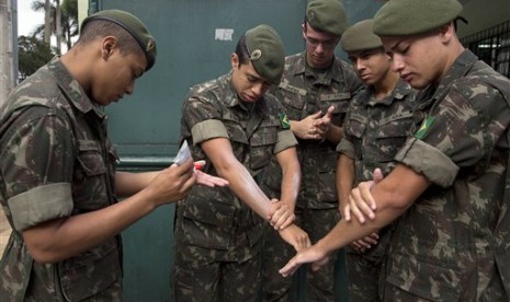 Tentara mengoleskan losion antinyamuk saat bersiap melakukan pembersiahn nyamuk Aedes aegypti yang menukarkan virus Zika di Sao Paulo, Brasil, Rabu, 20 Januari 2016.