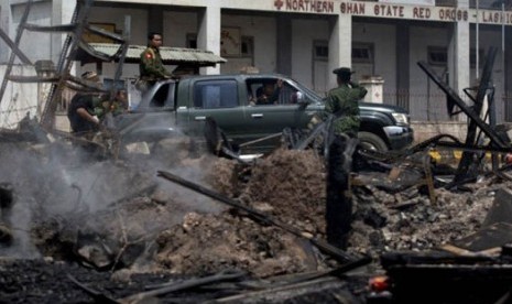 Tentara Myanmar melintasi bangunan yang terbakar yang menampung sebuah panti asuhan untuk anak-anak Muslim di Lashio, Myanmar, Kamis (30/5).