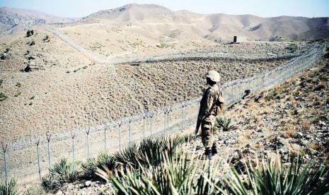 Tentara Pakistan berjaga di sepanjang pagar di perbatasan Afghanistan.