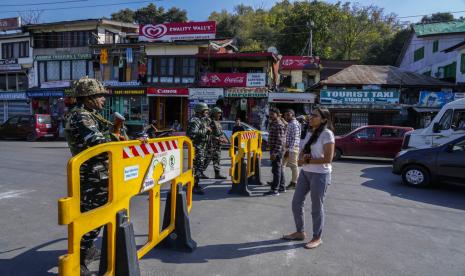 Tentara paramiliter India berjaga-jaga saat turis meminta izin untuk menyeberangi pos pemeriksaan sementara di dekat Danau Dal di Srinagar, Kashmir yang dikuasai India, Rabu, 5 Oktober 2022. Keamanan telah ditingkatkan saat Menteri Dalam Negeri India Amit Shah menjalani tiga hari kunjungan ke wilayah yang disengketakan.