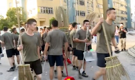 Tentara Pembebasan Rakyat bekerja membersihkan jalanan Hong Kong dari puing di lokasi protes di Hong Kong Baptist University, Sabtu (16/11). 