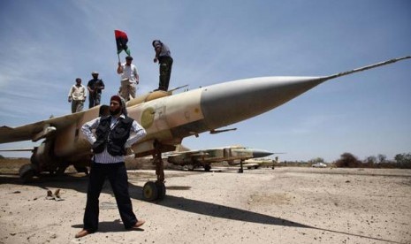 Tentara pemberontak berdiri di depan jet tempur Mig-23 di kota Misrata, Libya, dalam foto file yang diambil tanggal 28 Mei tahun 2011.