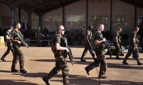 Tentara Prancis berjalan melewati sebuah hanggar di pangkalan udara militer Mali di Bamako, Senin (14/1). (Reuters/Joe Penney)