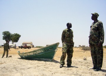 Tentara Somalia berjaga-jaga di garis pantai Milaxaar, 28 Maret 2011. Sebanyak 84 perompak sudah ditangkap sejak 2007 namun aksi ini terus merajalela. Perahu ini diduga milik perompak dan ada radio dari bantuan Inggris di dalamnya.