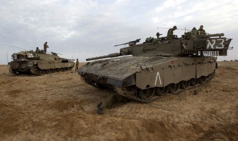  Tentara Zionis Israel mempersiapkan tank di dekat perbatasan dengan Jalur Gaza, Sabtu (17/11). (Reuters/Ronen Zvulun)