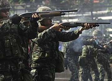 Tentara Thailand tampak menembakkan peluru karet ke arah demonstran anti-pemerintah di Bangkok, 14 Mei 2010.