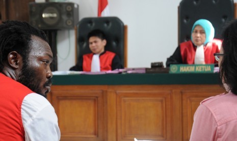 Terdakwa bandar narkoba sindikat jaringan internasional asal Nigeria Tobe Chukwu Ephriam Ihenko (kiri) mengikuti sidang dengan agenda pembacaan tuntutan di Pengadilan Negeri Kota Depok, Jawa Barat, Selasa (12/4).  (Antara/Indrianto Eko Suwarso)