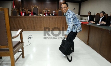 Terdakwa dugaan kasus penyalahgunaan wewenang dan korupsi, Jero Wacik mengambil tas saat akan mengikuti sidang di Pengadilan Tipikor, Jakarta, Senin (23/11). 