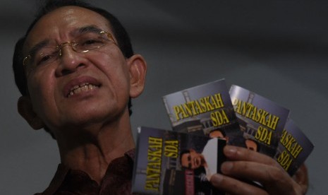 Terdakwa kasus dugaan korupsi dana haji Suryadharma Ali menunjukkan buku karyanya sebelum menjalani persidangan di Pengadilan Tipikor, Jakarta, Senin (11/1). 