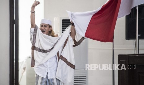 Terdakwa kasus dugaan penganiayaan terhadap remaja Bahar bin Smith memegang bendera merah putih sesuai sidang.