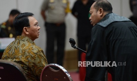  Terdakwa kasus dugaan penistaan agama Basuki Tjahaja Purnama berbincang bersama kuasa hukumnya saat menjalani sidang lanjutan dengan agenda pembacaan tuntutan di ruang auditorium Kementerian Pertanian, Jakarta, Selasa (11/4). 