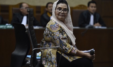 Terdakwa kasus korupsi alat kesehatan Siti Fadilah Supari berdiskusi dengan penasehat hukum saat jeda sidang lanjutan di Pengadilan Tipikor, Jakarta, Rabu (7/6). 