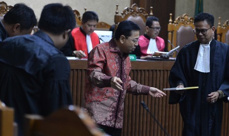 Defendant in e-ID card procurement graft-case Setya Novanto hands over a book about himself to the prosecutors after reading his defense statement in a hearing at Corruption Court, Jakarta, Friday (April 13). 