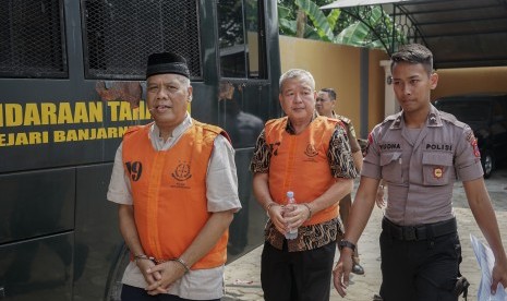 Terdakwa kasus mafia bola Dwi Irianto alias Mbah Putih (kiri) dan Tjan Ling Eng alias Johar Ling Eng (tengah), dikawal petugas menuju ruang sidang di Pengadilan Negeri Banjarnegara, Jateng, Senin (24/06/2019). 