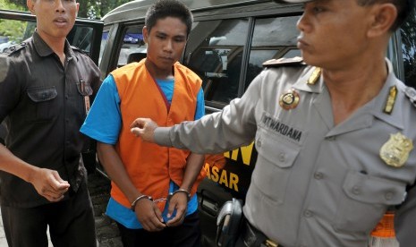 Terdakwa kasus pembunuhan anak, Agustay Hambamay (tengah), digiring petugas kejaksaan dan polisi saat akan menjalani persidangan di Pengadilan Negeri Denpasar, Bali, Kamis (17/12). 