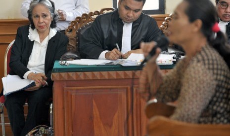 Terdakwa kasus pembunuhan anak, Margriet Megawe (kiri), mendengar keterangan saksi dalam persidangan di Pengadilan Negeri Denpasar, Bali, Kamis (17/12). 