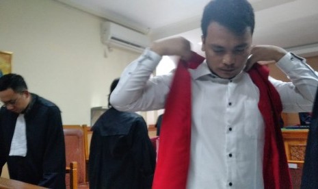 Terdakwa kasus pembunuhan satu keluarga di Bekasi, Haris Simamora, sedang memasang rompi tahanan usai melaksanakan sidang perdananya di Pengadilan Negeri Bekasi, Senin (11/3).