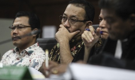 Terdakwa kasus penyuapan oknum di Kejati DKI Jakarta Dandung Pamularno (kiri) dan Sudi Wantoko (tengah) mendengarkan keterangan saksi saat menjalani sidang lanjutan di Pengadilan Tipikor, Jakarta, Rabu (29/6). 