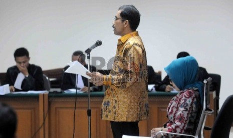 Terdakwa kasus suap sengketa pilkada yang juga mantan Walikota Palembang Romi Herton (kiri) bersama istrinya Masyitoh (kanan) bersiap mengikuti sidang dengan agenda pledoi terdakwa di Pengadilan Tipikor, Jakarta, Senin (23/2).