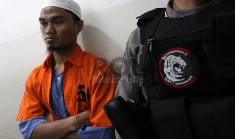 Terdakwa kasus teroris Poso, Amir dijaga petugas sebelum menjalani sidang lanjutan di Pengadilan Negeri Jakarta Timur, Rabu (19/2)