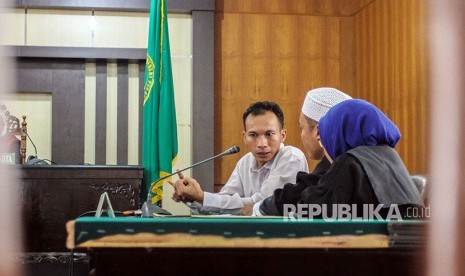 Terdakwa penyebar ujaran kebencian Jasriadi (Saracen Grup) berdialog dengan penasihat hukum usai mendengarkan pembacaan vonis di Pengadilan Negeri (PN) Pekanbaru, Jumat (6/4).