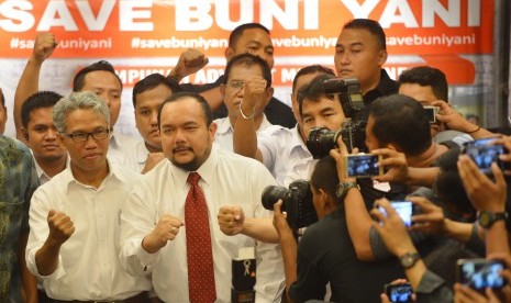 Terlapor kasus dugaan pengeditan video Ahok, Buni Yani (kiri) bersama pendukungnya mengepalkan tangan sebelum memberikan konferensi pers di Jakarta, Senin (7/11).