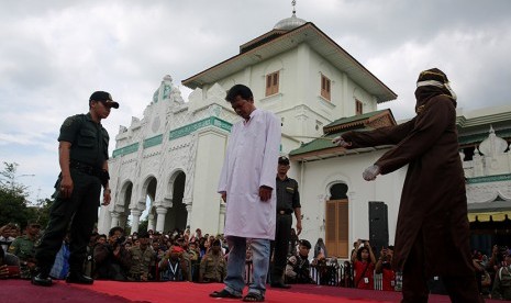 Terpidana kasus maisir atau judi dieksekusi cambuk dengan menggunakan rotan oleh algojo di halaman Masjid Baiturrahim, Ulee Lheu, Banda Aceh, Aceh, Senin (28/12).