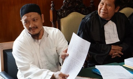 Terpidana mati kasus narkoba Freddy Budiman (kiri), menunjukkan surat permohonan tobat nasuha pada sidang PK di Pengadilan Negeri Cilacap, Jawa Tengah, Rabu (25/5).