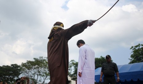 Terpidana pelanggar peraturan daerah (qanun) Syariat Islam (tengah) menjalani hukuman cambuk di halaman Masjid Rukoh, Kecamatan Syiah Kuala, Banda Aceh, Aceh, Selasa (1/3).