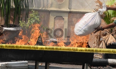 Tersangka bersama barang bukti narkoba dihadirkan saat pemusnahan barang bukti narkoba jenis sabu, ganja dan pil ekstasi di Polres Jakbar, Jakarta Barat, Rabu (19/8).