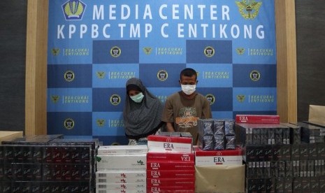 Tersangka bersama hasil sitaan barang penyelundupan berupa rokok ilegal.