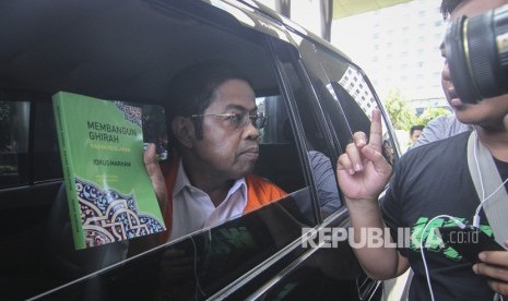 Tersangka kasus dugaan suap proyek pembangunan PLTU Riau-1, Idrus Marham, membagikan buku seusai menjalani pemeriksaan di gedung KPK, Jakarta, Jumat (28/12/2018). 